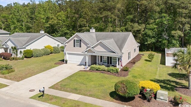 680 Twinflower St, Little River, SC 29566 - view of front of property featuring covered porch, concrete driveway, a garage, and a front yard