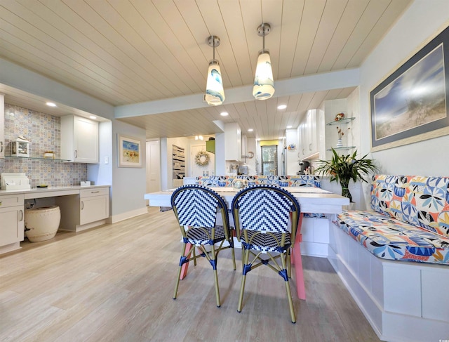 dining area featuring baseboards, wooden ceiling, and light wood finished floors