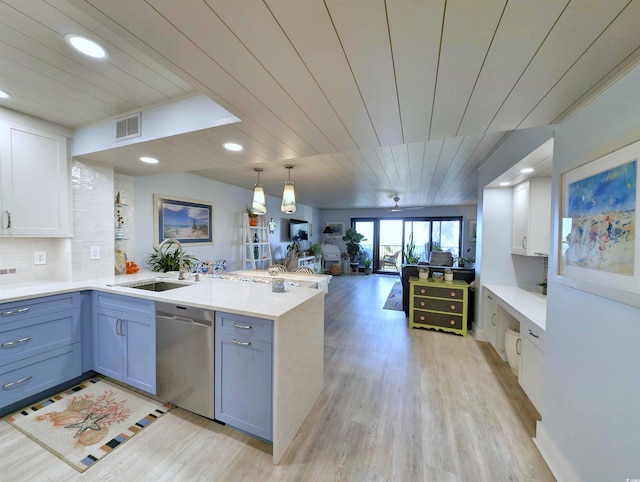 kitchen featuring a peninsula, open floor plan, a sink, light wood-style flooring, and dishwasher