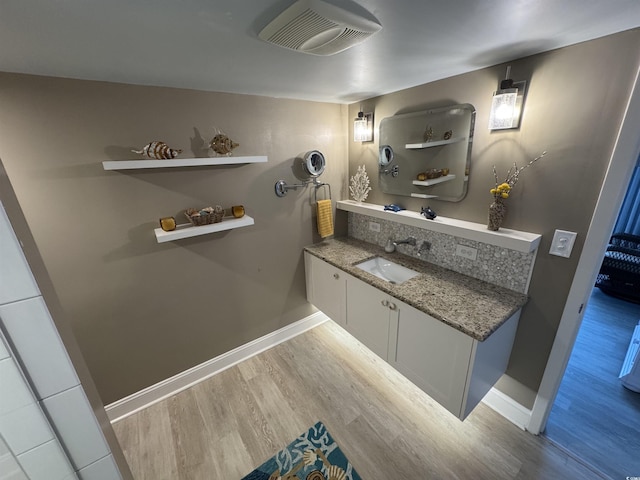bathroom with baseboards, visible vents, wood finished floors, and vanity