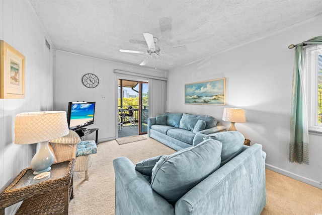 carpeted living area featuring baseboards, a ceiling fan, a textured ceiling, and visible vents