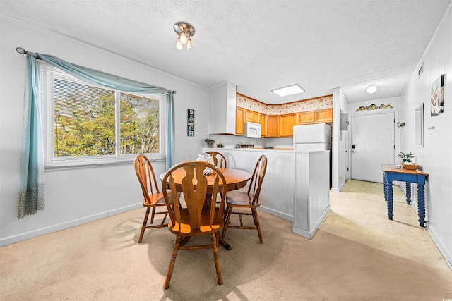 dining space with baseboards, a textured ceiling, visible vents, and a healthy amount of sunlight