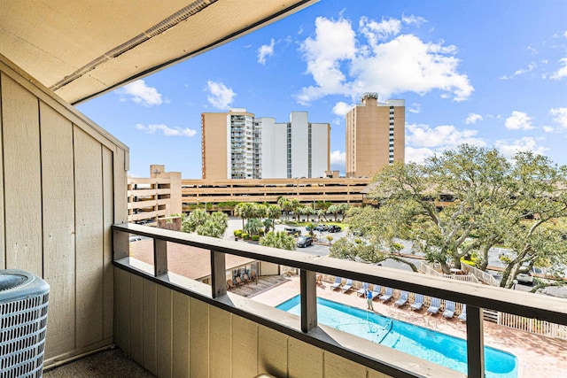 balcony featuring a city view and cooling unit