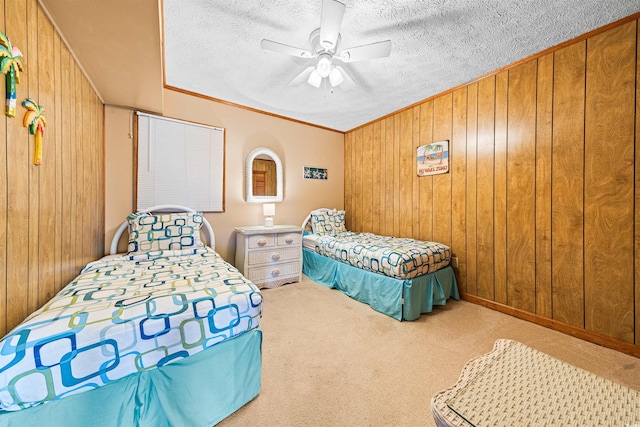 carpeted bedroom with wood walls, a textured ceiling, a ceiling fan, and ornamental molding