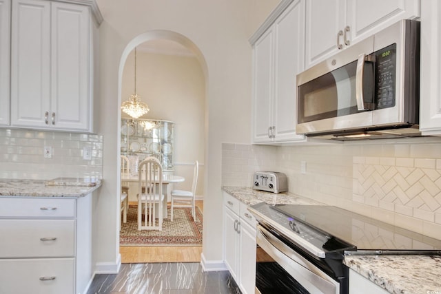 78 Saltwind Loop, Murrells Inlet, SC 29576 - kitchen with white cabinets, stainless steel appliances, arched walkways, and backsplash