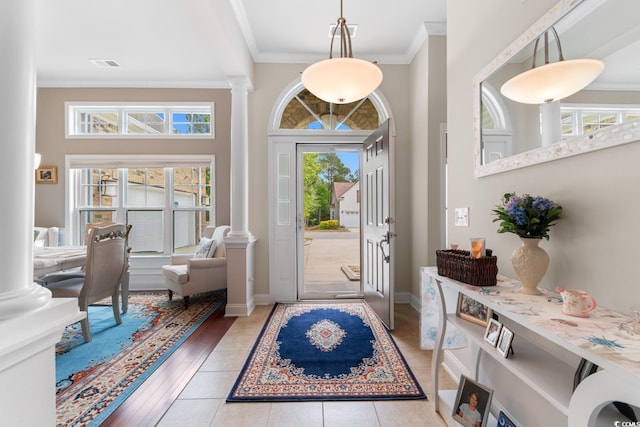 entryway with visible vents, ornamental molding, decorative columns, and baseboards