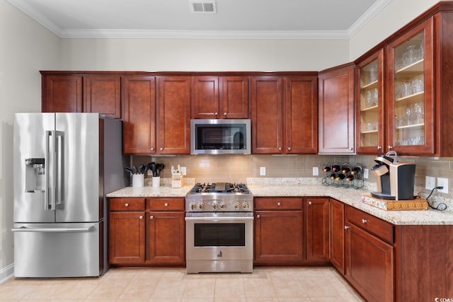 kitchen featuring crown molding, appliances with stainless steel finishes, and light stone countertops