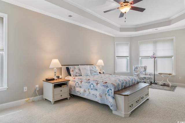 bedroom featuring light carpet, a raised ceiling, baseboards, visible vents, and ornamental molding