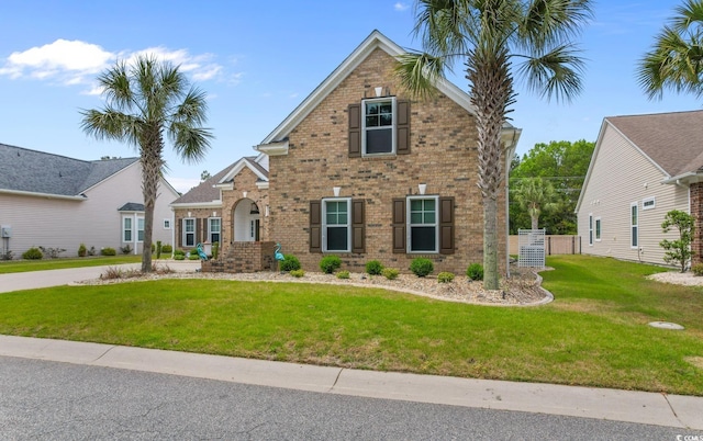 traditional home featuring brick siding and a front yard