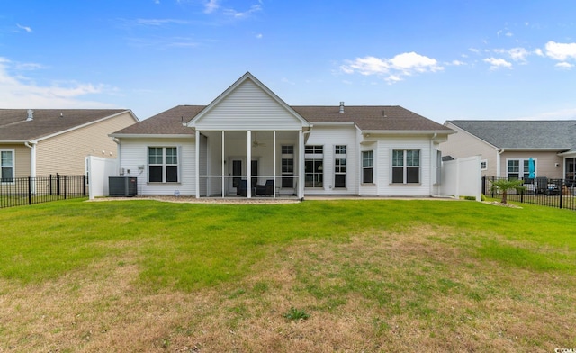 rear view of property with fence, a sunroom, a yard, and cooling unit