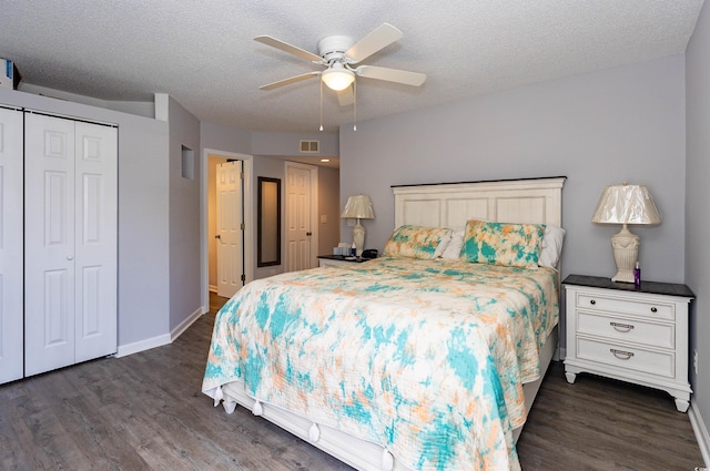 bedroom featuring dark wood-style flooring, a textured ceiling, visible vents, and baseboards