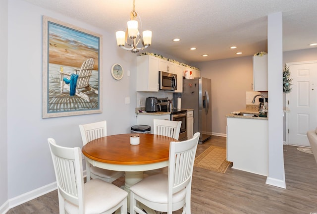dining room featuring recessed lighting, baseboards, and wood finished floors