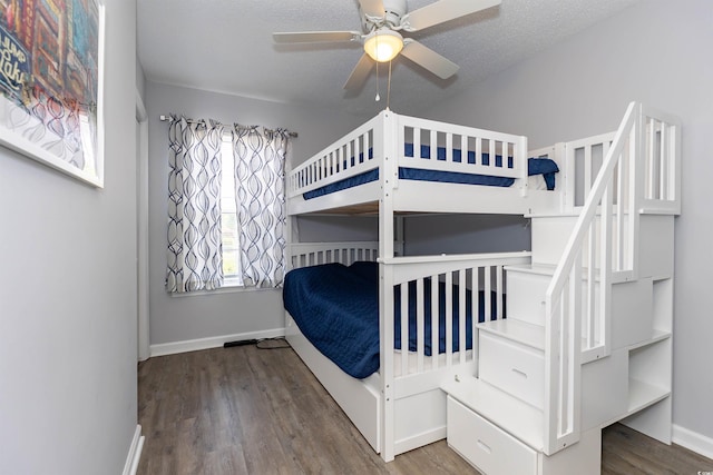bedroom featuring a ceiling fan, baseboards, and wood finished floors