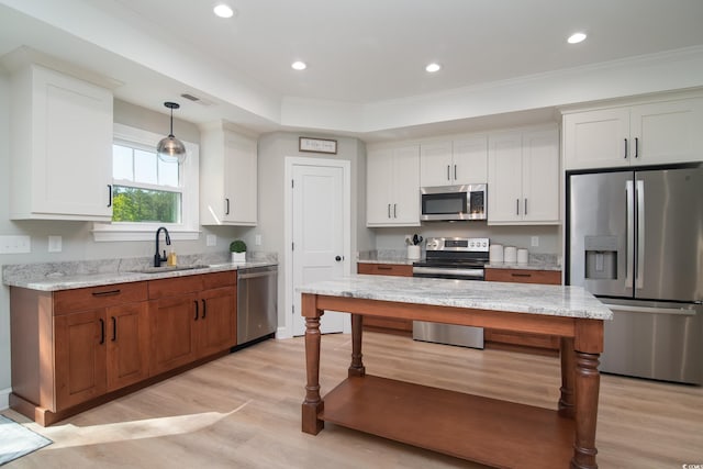 294 Field Loop Rd, Georgetown, SC 29440 - kitchen featuring appliances with stainless steel finishes, a sink, light wood finished floors, white cabinetry, and ornamental molding