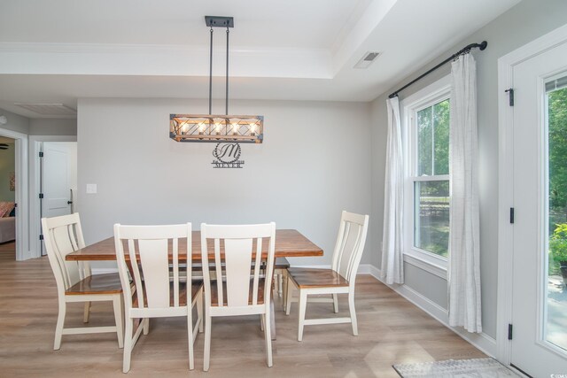 294 Field Loop Rd, Georgetown, SC 29440 - dining room featuring light wood-style flooring, a raised ceiling, and ornamental molding