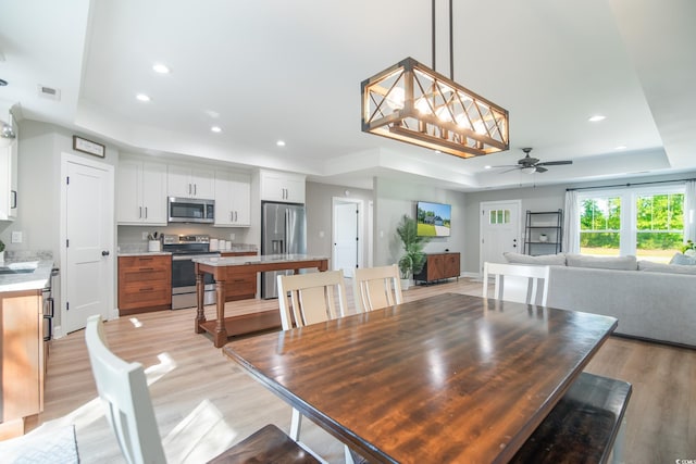 294 Field Loop Rd, Georgetown, SC 29440 - dining area featuring a tray ceiling, ceiling fan, light wood-type flooring, and recessed lighting