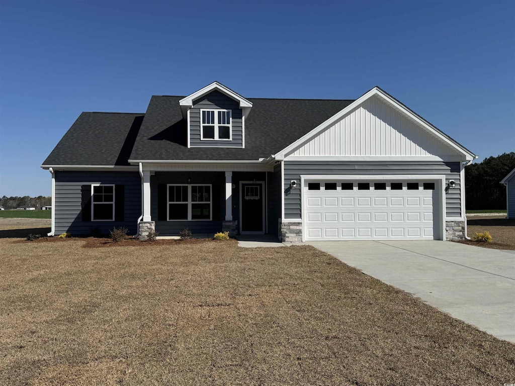 craftsman-style home with a porch, an attached garage, driveway, and stone siding