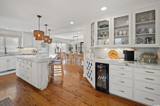 109 Pioneer Loop, Georgetown, SC 29440 - kitchen with wine cooler, tasteful backsplash, white cabinetry, a sink, and a kitchen island