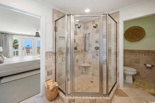 109 Pioneer Loop, Georgetown, SC 29440 - ensuite bathroom featuring a shower stall, toilet, tile walls, crown molding, and a ceiling fan