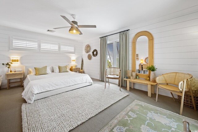 109 Pioneer Loop, Georgetown, SC 29440 - carpeted bedroom featuring multiple windows, wooden walls, and ceiling fan