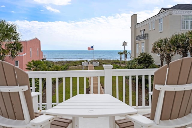 balcony with a water view and outdoor dining space