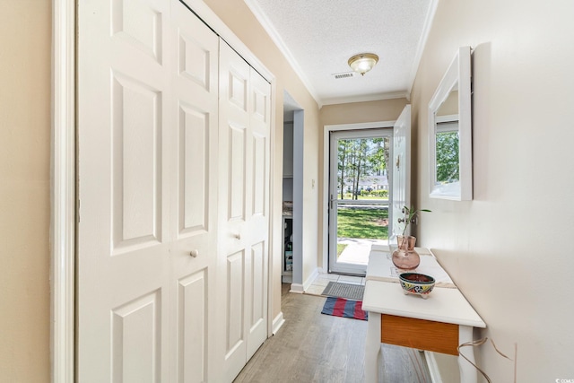 6734 Blue Heron Blvd Unit 104, Myrtle Beach, SC 29588 - doorway to outside featuring wood finished floors, a textured ceiling, visible vents, baseboards, and ornamental molding