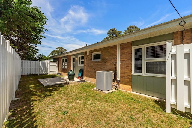 617 Hibiscus Ave Unit 617, Myrtle Beach, SC 29577 - back of house with central AC, a patio, a fenced backyard, brick siding, and a yard