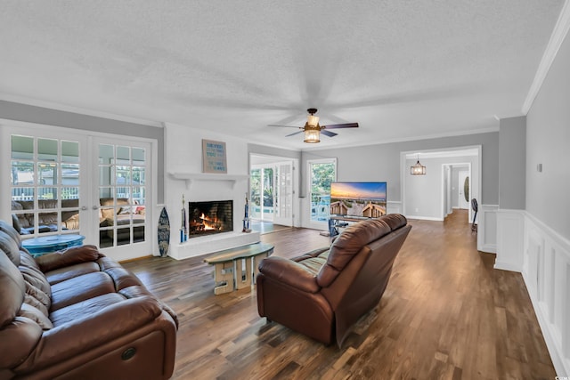 living room featuring crown molding, a textured ceiling, french doors, and dark wood-type flooring
