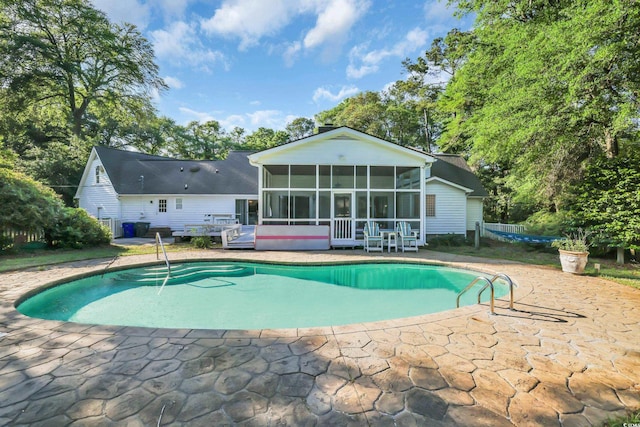 pool featuring a patio and a sunroom