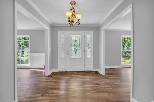 entrance foyer with crown molding, baseboards, wood finished floors, and a notable chandelier