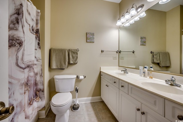 bathroom with baseboards, a sink, tile patterned flooring, and toilet