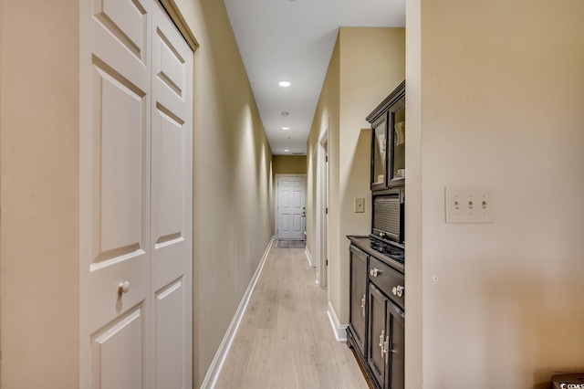 corridor featuring recessed lighting, baseboards, and light wood-style flooring