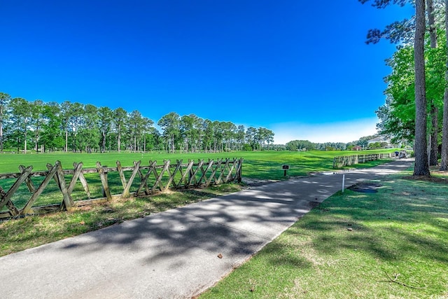 view of property's community featuring fence and a yard