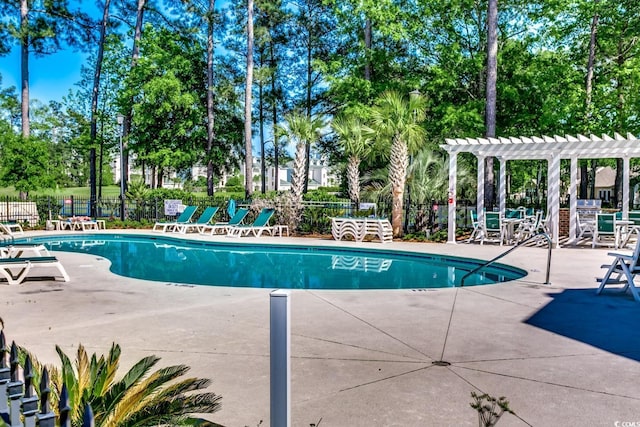 community pool featuring fence, a pergola, and a patio area