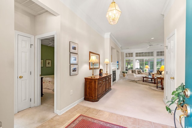 1617 Tradition Club Dr, Pawleys Island, SC 29585 - foyer with crown molding, a glass covered fireplace, light carpet, ceiling fan with notable chandelier, and light tile patterned floors