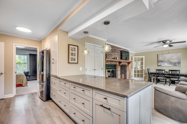 8209 Timber Ridge Rd, Conway, SC 29526 - kitchen with freestanding refrigerator, open floor plan, a peninsula, ornamental molding, and dark stone countertops