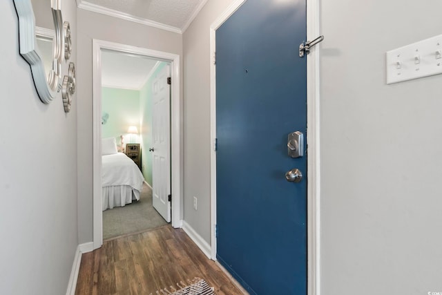 hall with dark wood-type flooring, baseboards, and crown molding