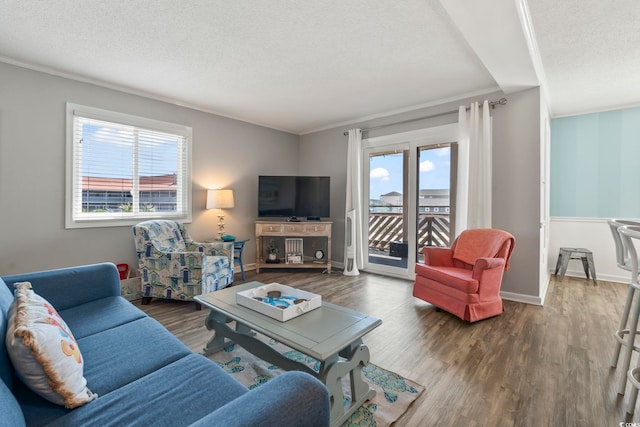 living area with ornamental molding and wood finished floors