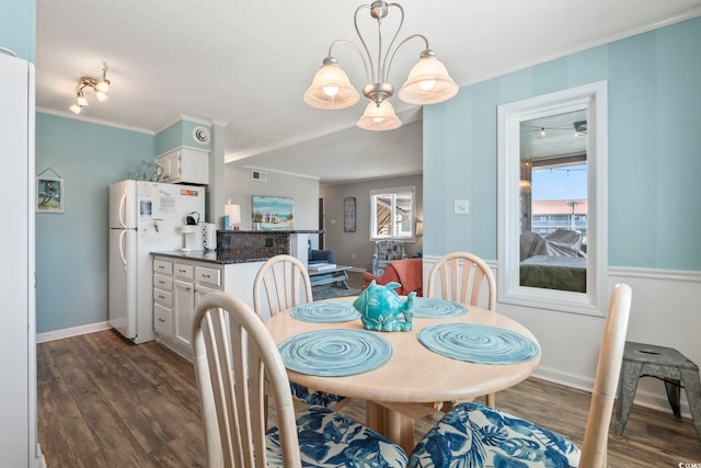 dining room with baseboards, visible vents, ornamental molding, and dark wood-type flooring