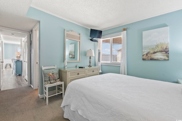 bedroom with crown molding, a textured ceiling, and carpet
