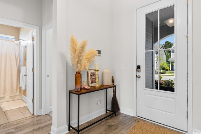 foyer entrance with light wood-type flooring and baseboards