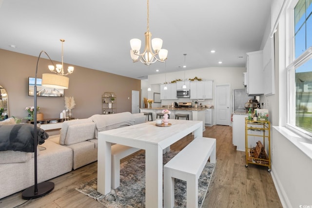 dining room featuring recessed lighting, an inviting chandelier, and light wood-type flooring