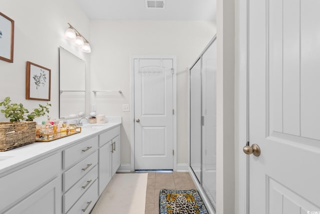 full bath featuring double vanity, visible vents, a shower stall, a sink, and tile patterned floors