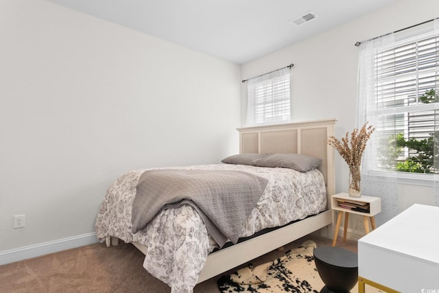 bedroom featuring carpet flooring, baseboards, visible vents, and multiple windows