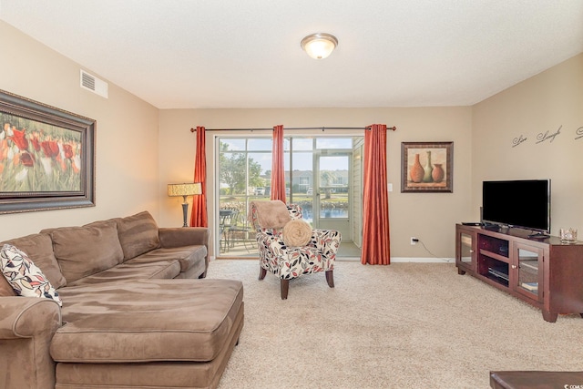 carpeted living area featuring baseboards and visible vents