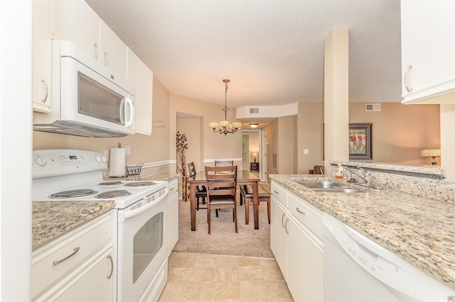 kitchen featuring visible vents, white appliances, white cabinetry, a chandelier, and a sink