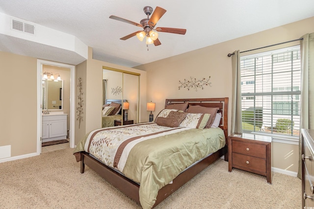 bedroom featuring visible vents, baseboards, a closet, and light colored carpet