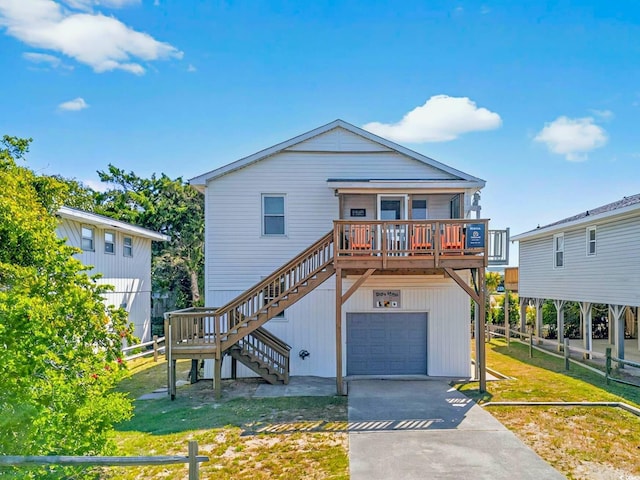 beach home with fence, a front lawn, stairway, and a garage