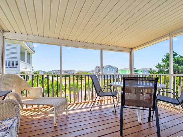 sunroom featuring a residential view and outdoor dining area