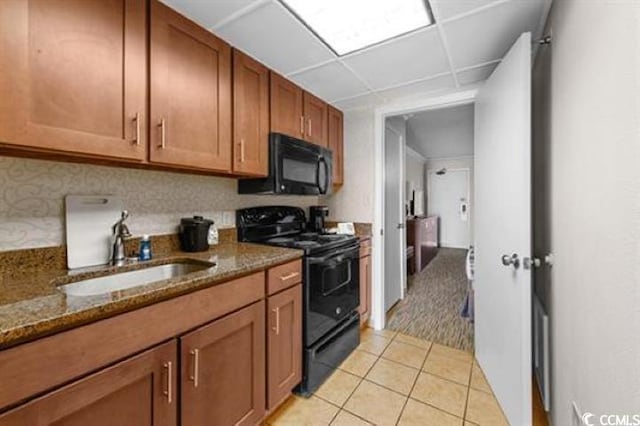 1105 S Ocean Blvd Unit 630, Myrtle Beach, SC 29577 - kitchen with black appliances, brown cabinets, dark stone counters, light tile patterned floors, and a sink